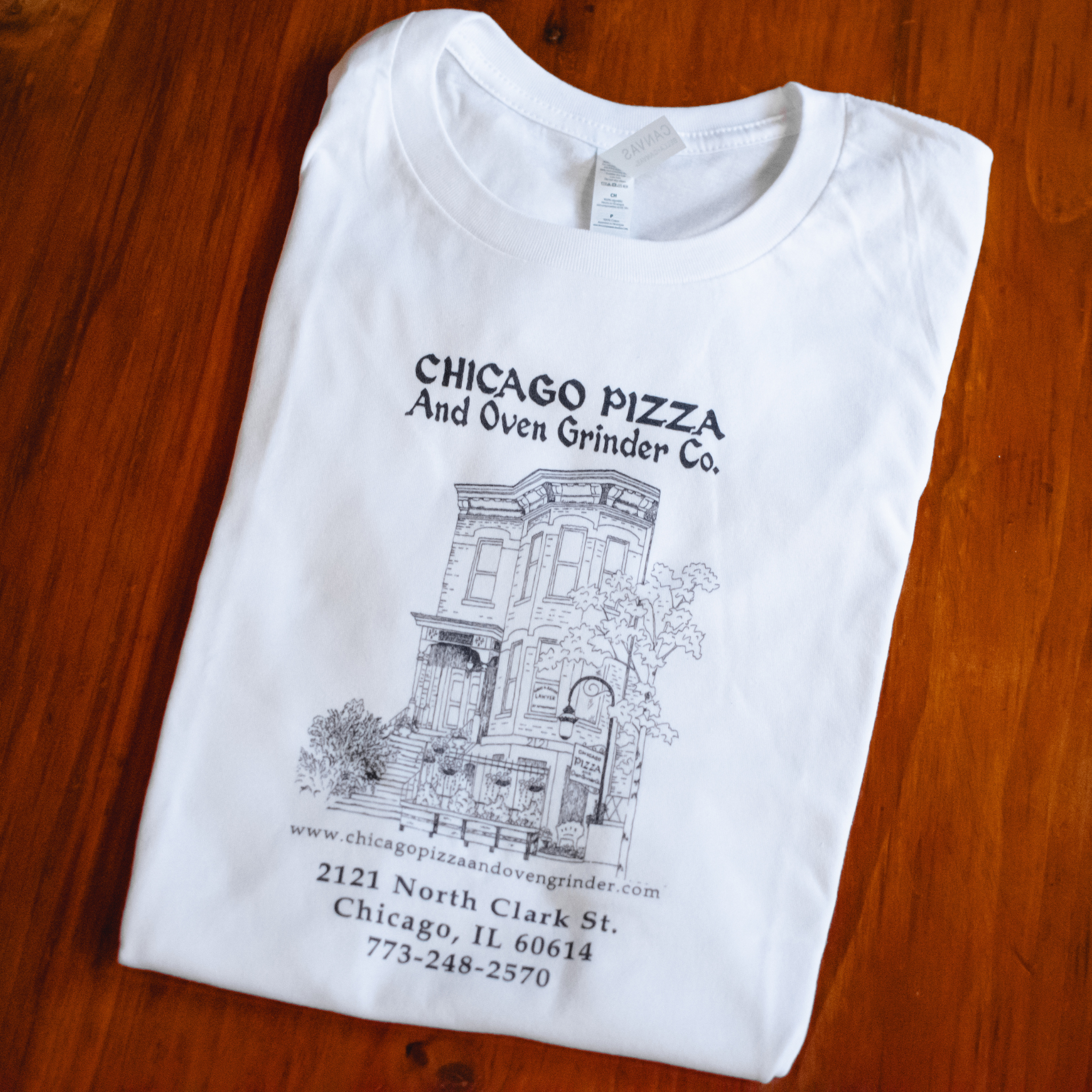 White t-shirt with black printed design on a wooden surface